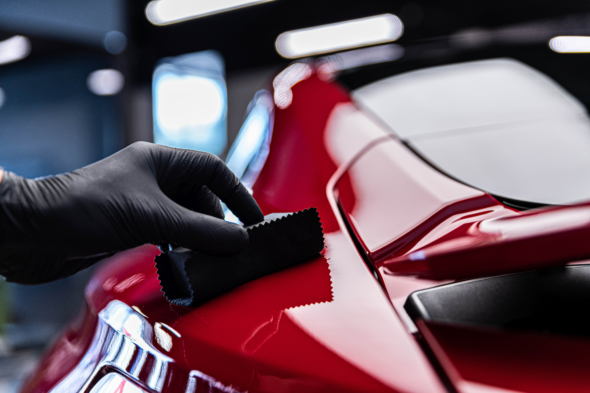 Hand polishing with microfiber cloth on red car